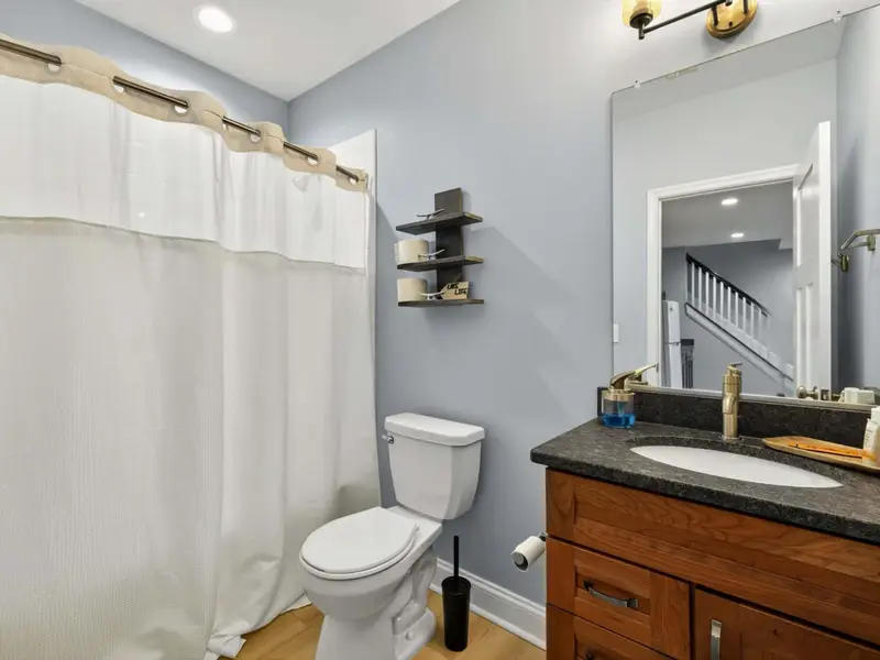 Hall Bath (Lower) - Walk-in shower with single vanity, serves Bedroom 5.
