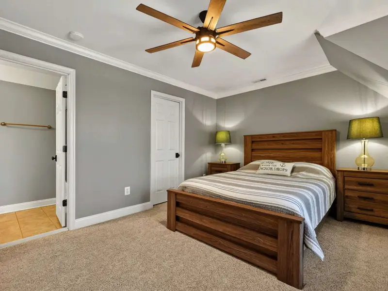 Upper Level Bedroom - Queen bed with paired nightstands and a private ensuite bath through the open door, a calm retreat after a full day on the lake.