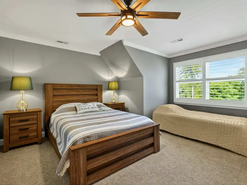 Upper Level Bedroom - Queen bed with striped linens, an alcove twin tucked under the dormer window, and a private ensuite for a versatile upper-level setup.