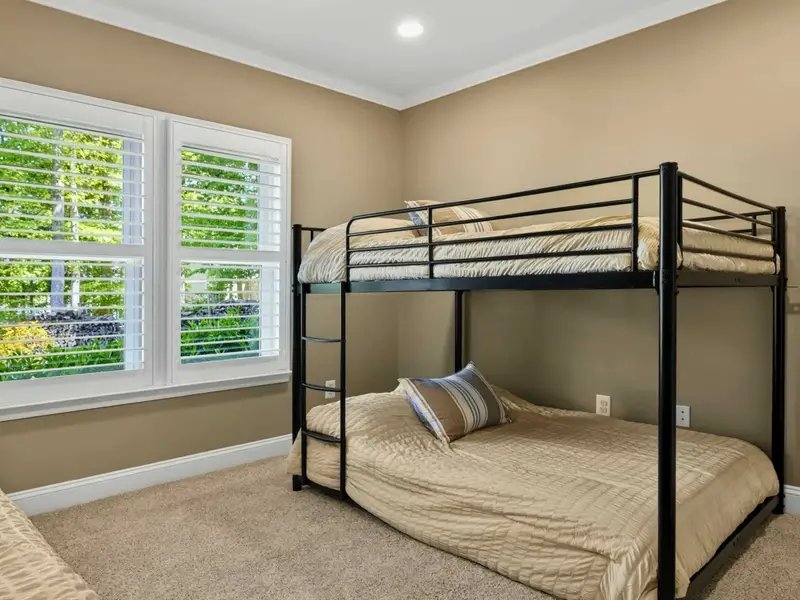 Bunk Room - Black metal bunks with two full-size mattresses, plantation-shuttered windows, and room to share for cousins, friends, and kids.