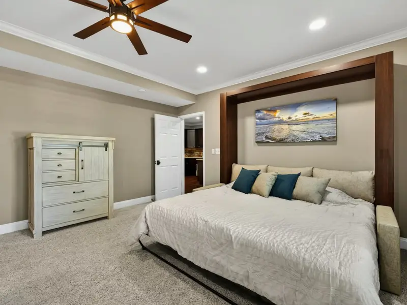 Bunk Room - The Murphy king made up with seaside-toned linens, paired with a sliding-door dresser and direct access to a dedicated bath.
