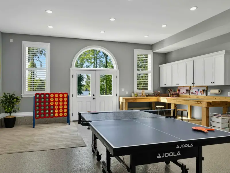 Game Room - Tournament-size ping pong table with French doors framing the trees outside, easy in-out between matches and the lake.