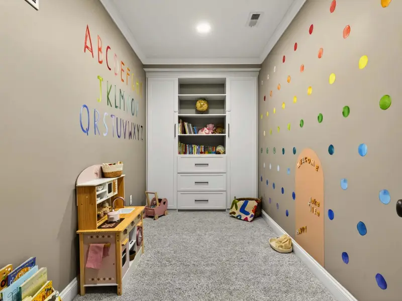 Children's Playroom - Hand-painted alphabet, a wooden play kitchen, a climbing wall, and a stocked book nook, the room that becomes the kids' headquarters.