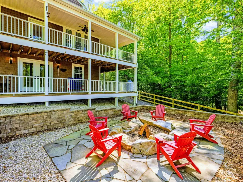 Backyard - Red Adirondack chairs ring the fire pit, the natural end to every day on the water.