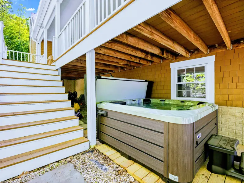 Hot Tub - Wide view of the sheltered hot tub area, with the deck stairs leading right up to the main level.
