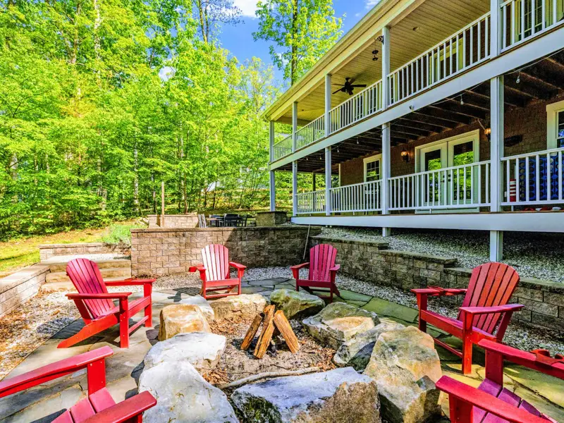 Patio - Multiple deck levels and a green canopy of mature trees frame the home.