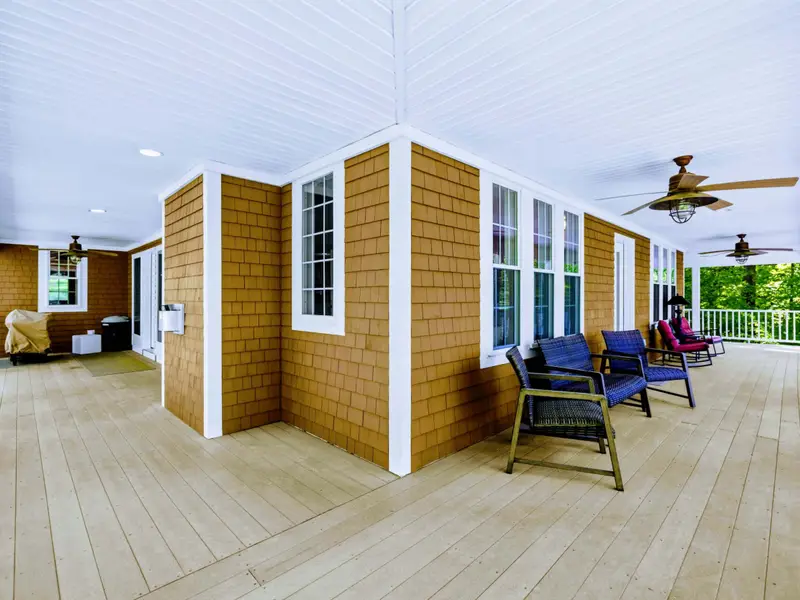 Upper Porch - Tucked-in seating with views of the wooded grounds and the lake beyond.