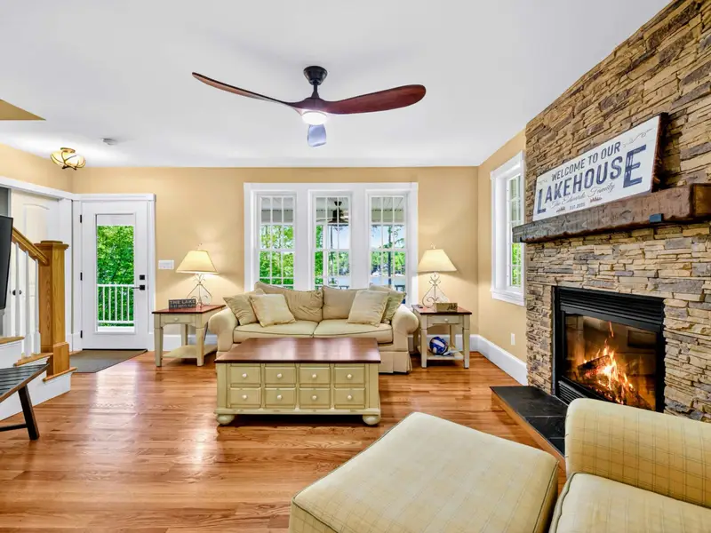 Living Room - A stacked-stone fireplace and 'Welcome to our Lakehouse' sign anchor the room where the trip comes together.
