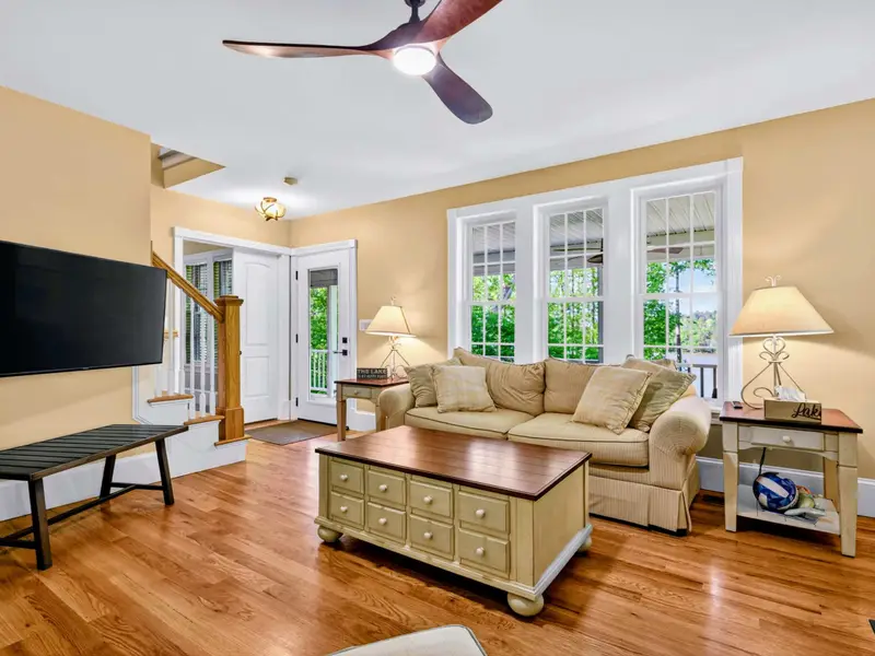 Living Room - Multiple sofas and chairs ringed around the fireplace, with a door opening to the deck just steps away.