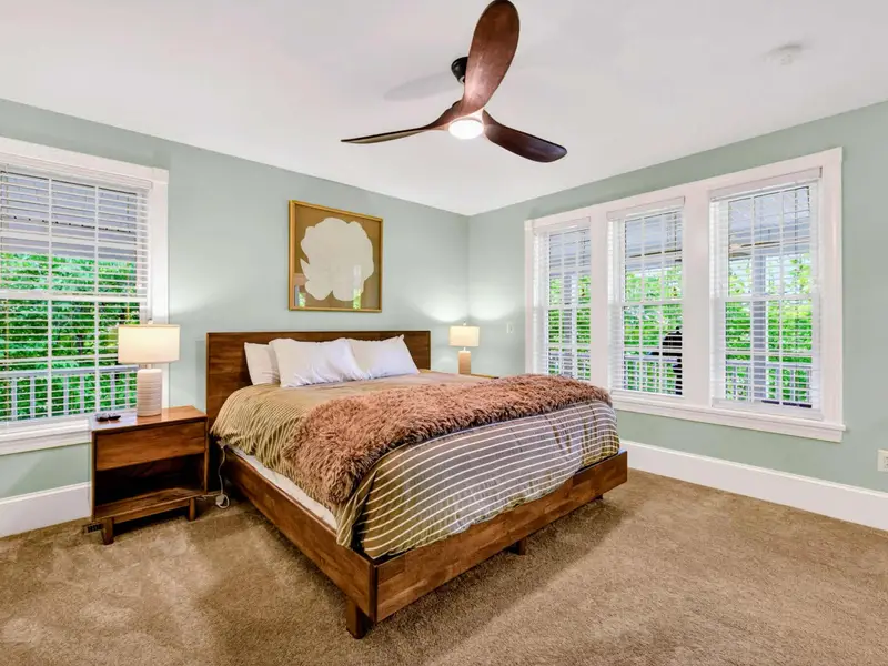 Primary Suite - Lots of natural light, a quiet color palette, and a king bed dressed for rest.