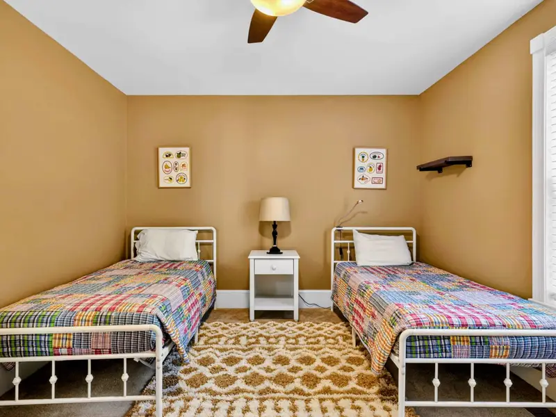 Twin Bedroom - Patterned rug, sunlit window, and matching twin beds make this room a kid-favorite.