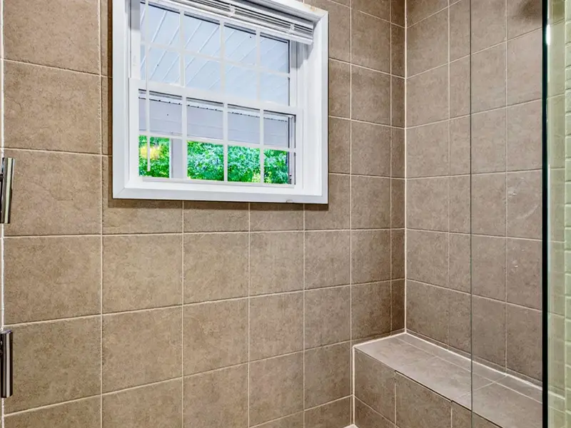 Primary Bath - Subway-style tile and a bench seat make the shower feel like a real retreat.