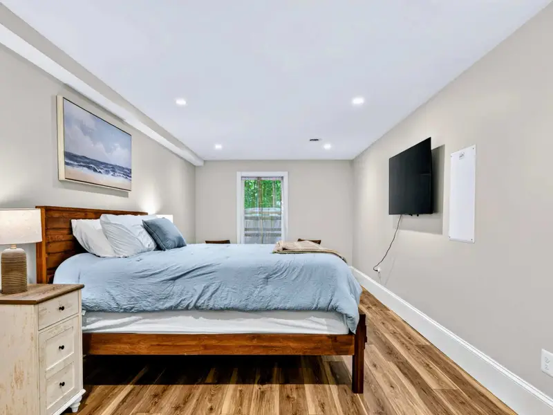 King Bedroom - Light gray walls and hardwood floors anchor a king bed dressed in lake-blue linens.