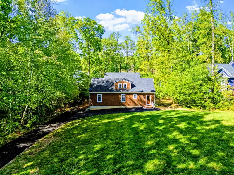 Exterior - The classic shake-shingled home set on its private 1.2-acre lot, with multiple deck levels facing the lake.