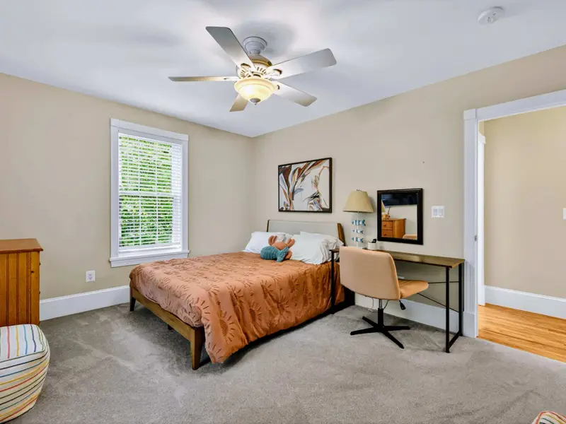 King Bedroom - A king bed dressed in warm rust tones, with a desk for the guest who needs a quiet workspace.