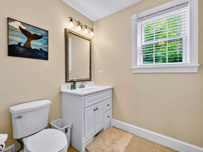 Hall Bath - Tan walls, framed whale-tail art, and a fresh white vanity make this main-level bath warm and welcoming.