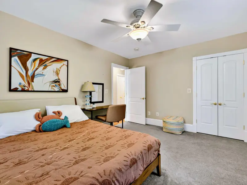 King Bedroom - Plush carpet, framed botanical art, and a king bed designed to feel like a private retreat.