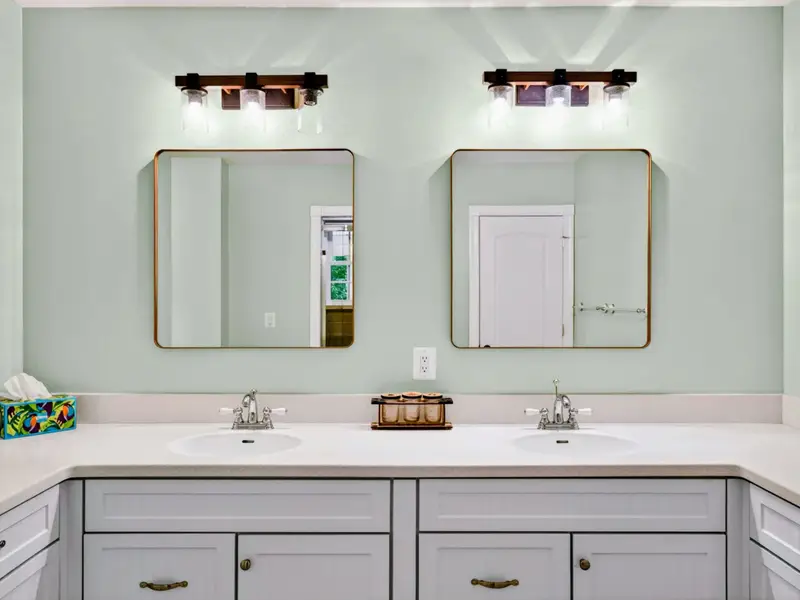 Primary Bath - Generous counter space and traditional white cabinetry keep the morning calm.