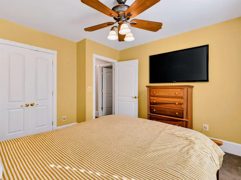 King Bedroom - Wall-mounted TV, generous closet space, and quiet main-level convenience.