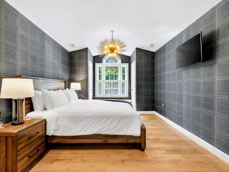 King Bedroom - Moody dark-denim wallpaper and a king bed make this room feel sophisticated and restful.