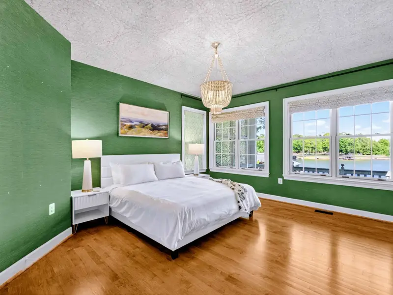 King Bedroom - Bold green walls and a king bed with the lake view through bright windows.