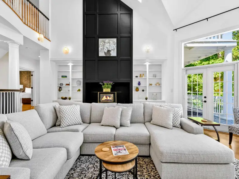 Great Room - Dark feature wall with custom millwork anchors the room beneath the vaulted ceiling.