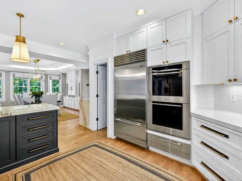 Kitchen - Wolf wall ovens with warming drawer tucked beside the island.