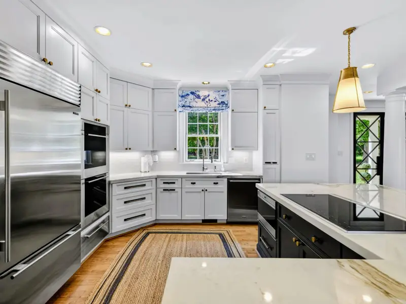 Kitchen Detail - Wolf range with double oven below, built-in Sub-Zero refrigerator beyond.