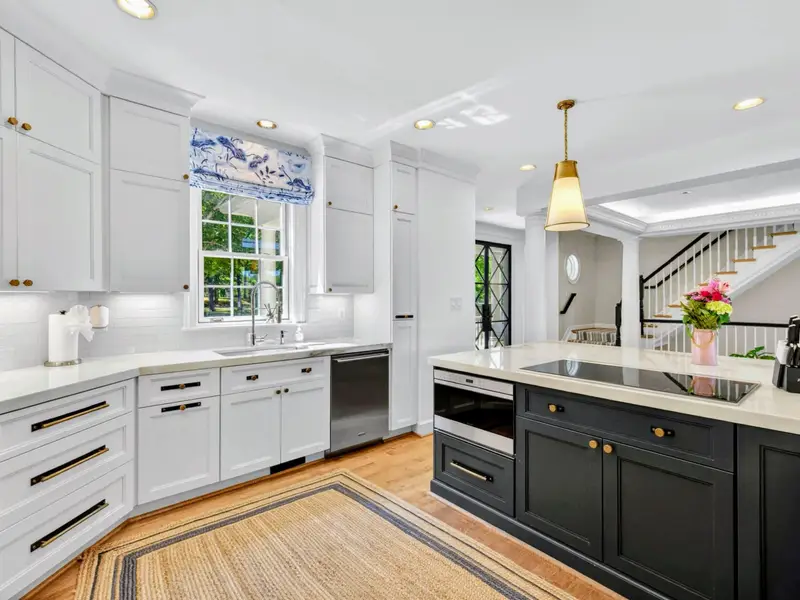 Kitchen Detail - Italian marble counters meet white cabinetry and brass hardware.
