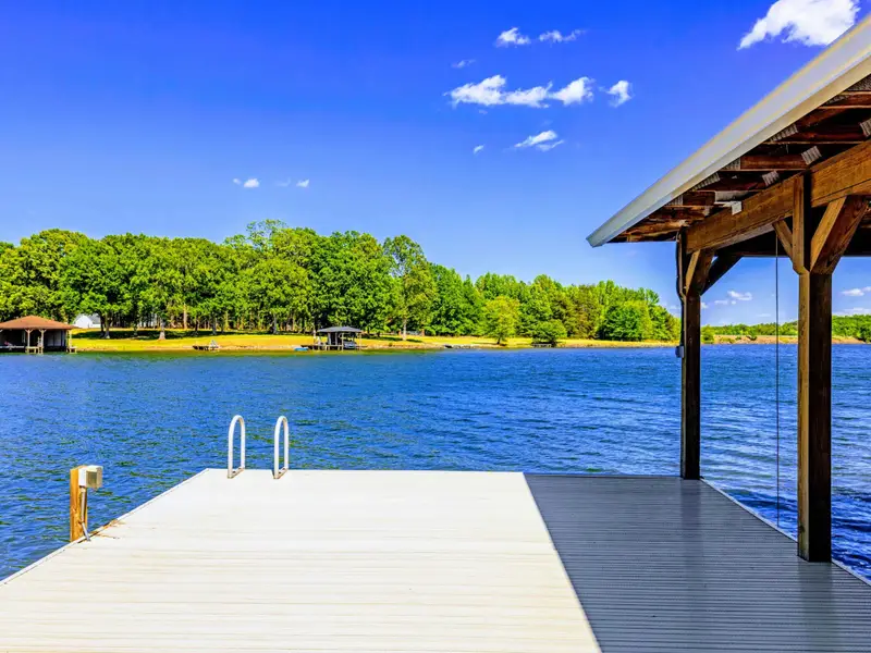 Boat Dock - Open platform with swim ladder steps into the cove, covered slips just to the side.