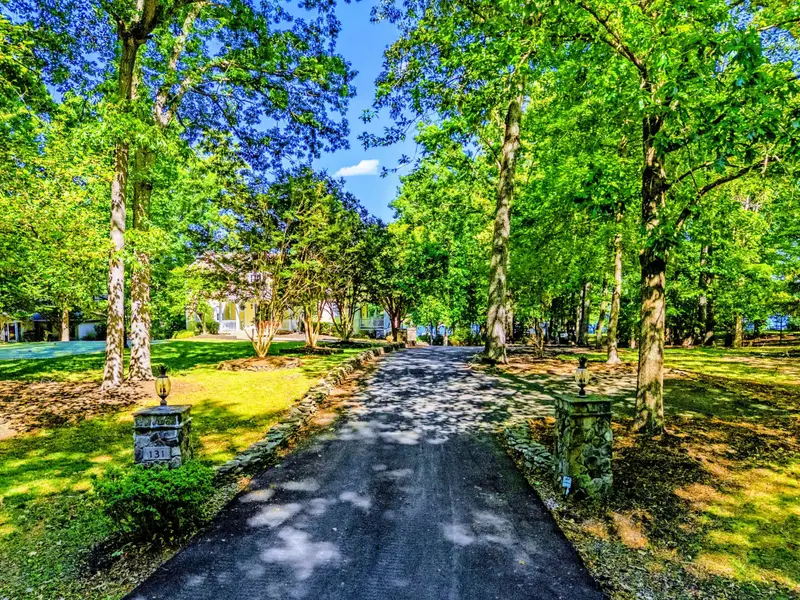 Approach - Open lawn and mature trees set the tone before you even reach the door.