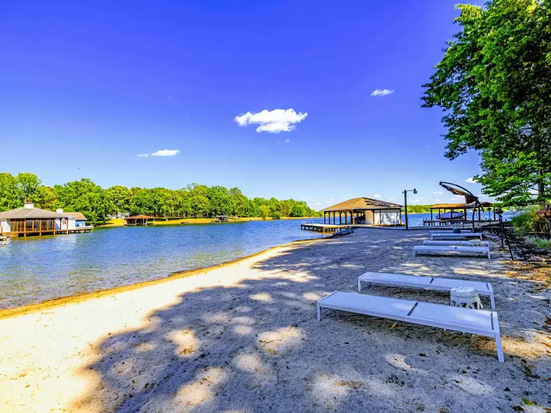 Beach - Sandy beach with sun loungers, boat dock just steps away, the lake stretching out in front.