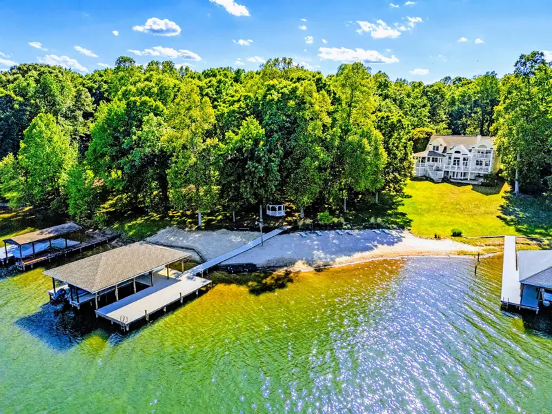 From Above - Wide aerial of the cove, the boat dock visible at the property line.