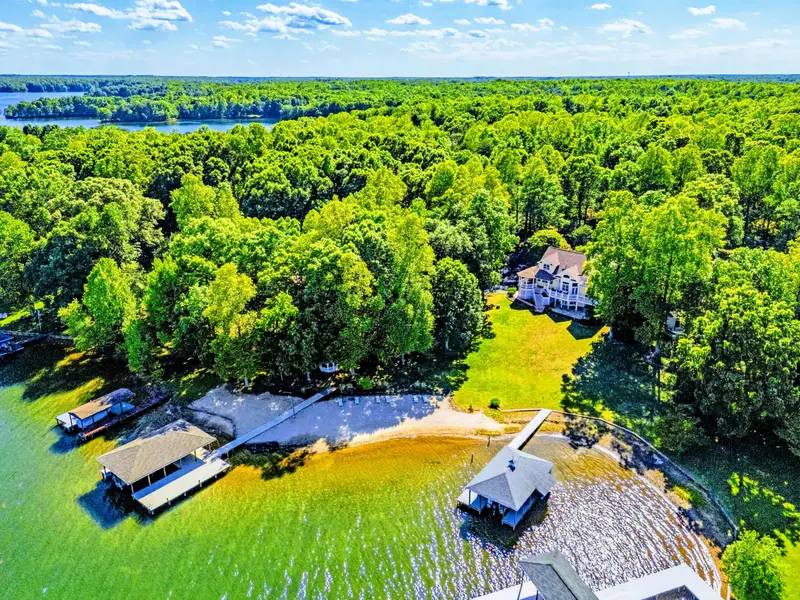 From Above - Mature trees frame a calm waterfront, the home tucked into the landscape.