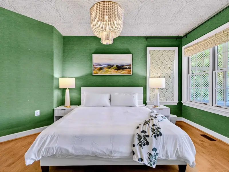 King Bedroom - Layered styling and a comfortable king bed in the green-walled bedroom.