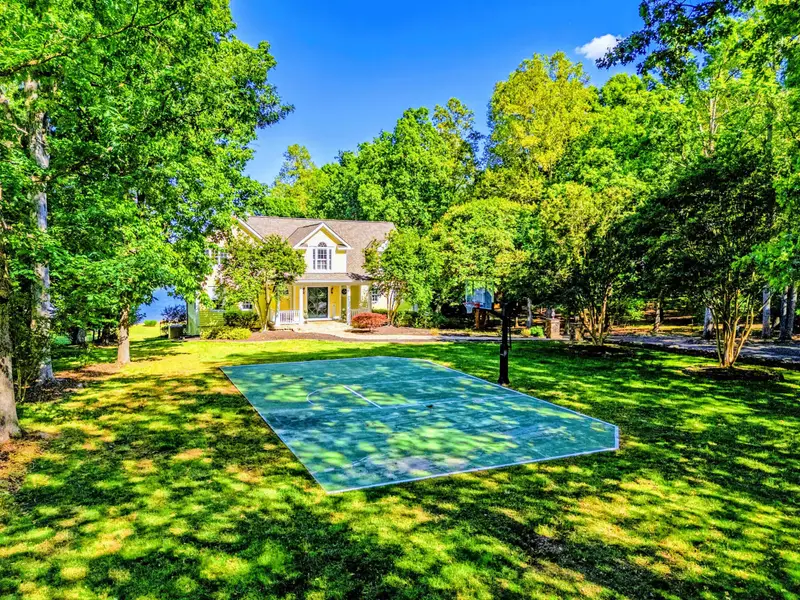 Front Yard - Manicured grounds anchor the property, with established landscaping throughout.