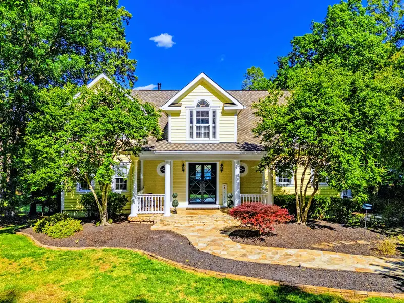Front Yard - The home set back from the road with established landscaping in the foreground.