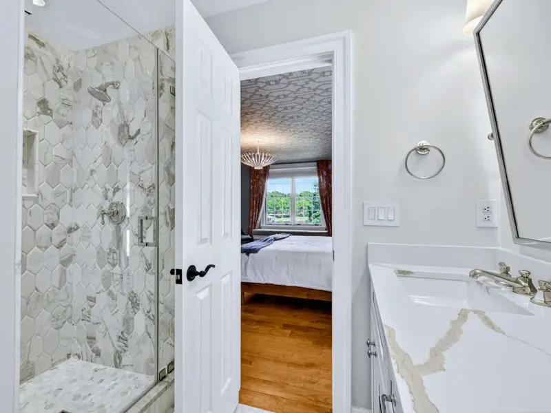 Ensuite Bath - Marble vanity with framed mirror, polished and warm.