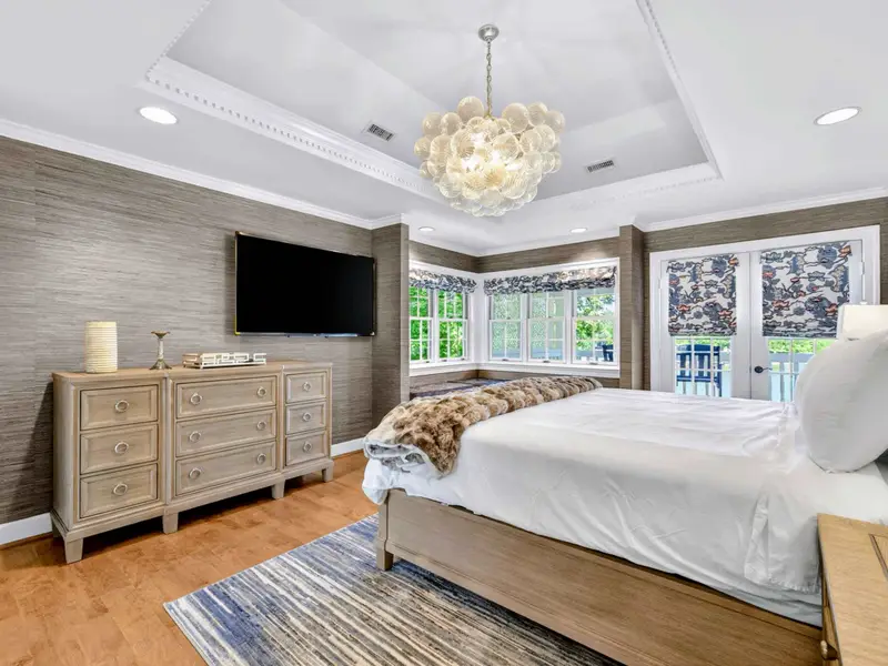 Primary Suite - The primary bedroom features a king bed framed by classic detailing and warm tones.