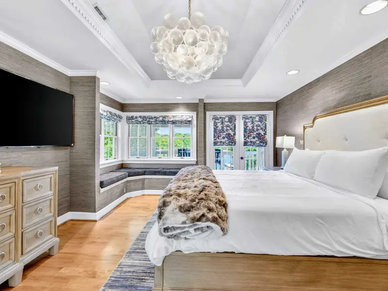 Primary Suite - Carved wood bed and night tables anchor the primary bedroom.