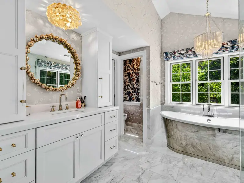Primary Bath - Custom dual vanity wall with built-in cabinetry, freestanding tub just beyond.