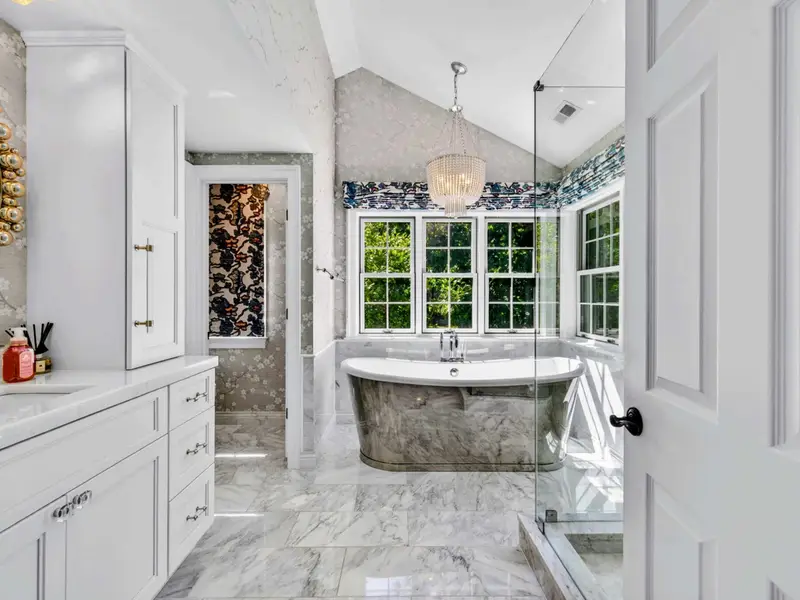 Primary Bath - Tub and shower zones flow together with consistent marble detailing.