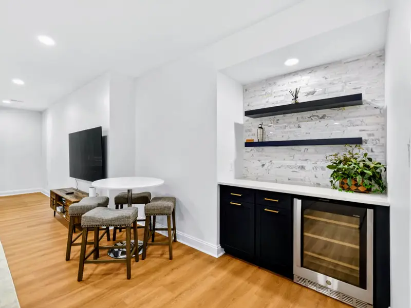 Bar - Dry bar with beverage center, mounted TV, and counter seating for snacks and drinks.
