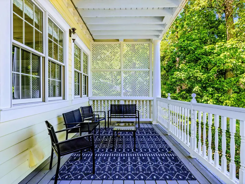 Deck - Layered outdoor rugs and a long bench make the porch feel as styled as inside.