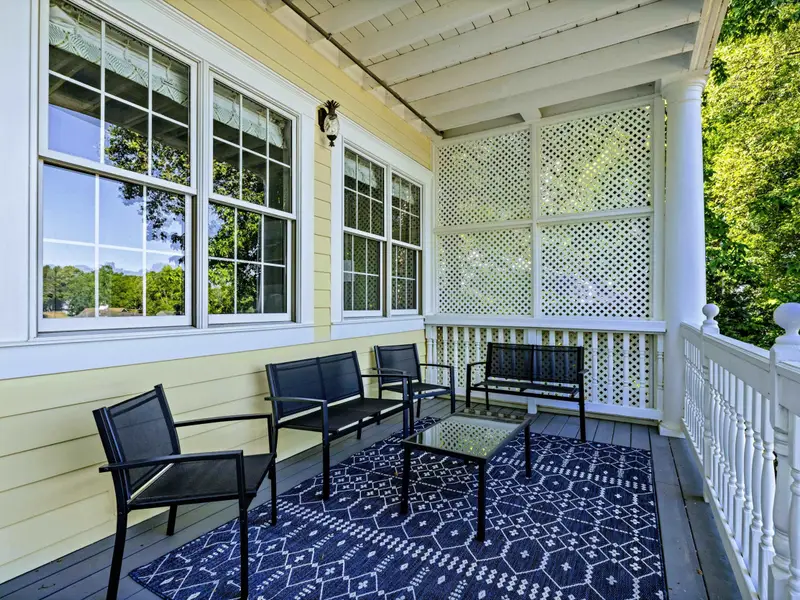 Deck - Detail of the covered porch seating with windows into the green bedroom behind.