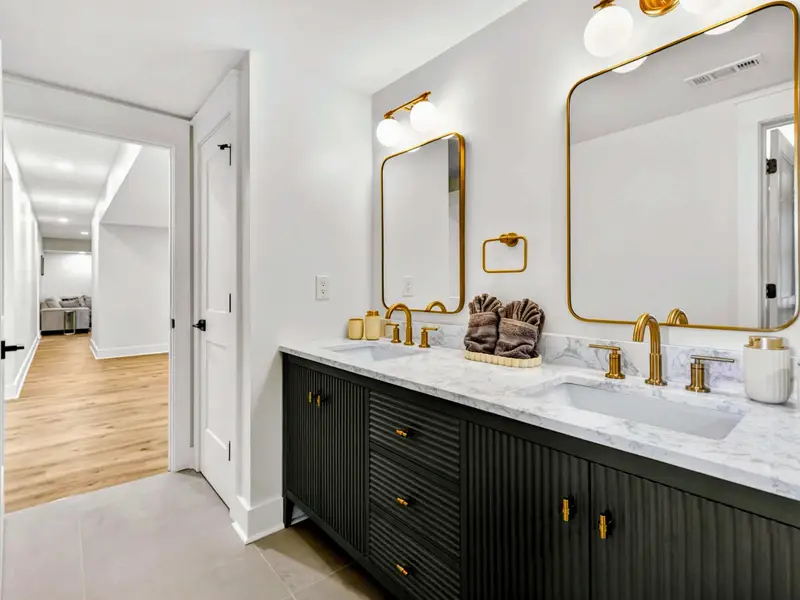 Ensuite & Hall - The lower suite's vanity opens to the hall that links the bedrooms, game room, and media lounge below.
