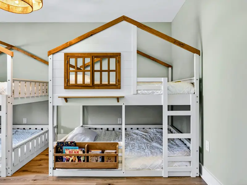 Treehouse Bunks - Gabled rooflines, shuttered windows, and built-in book bins turn bedtime into part of the adventure.
