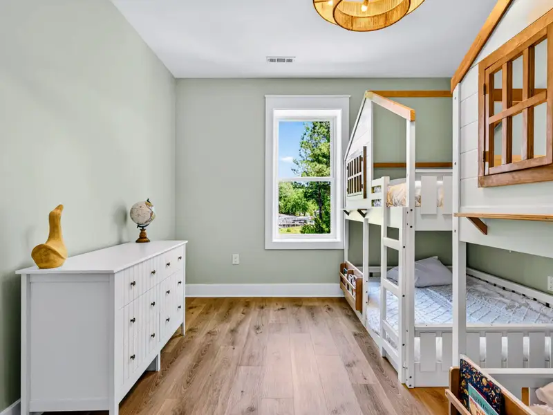 Bunk Room - Treetop views, a globe, and stocked book bins round out the playful lower-level treehouse bunk room built for kids.