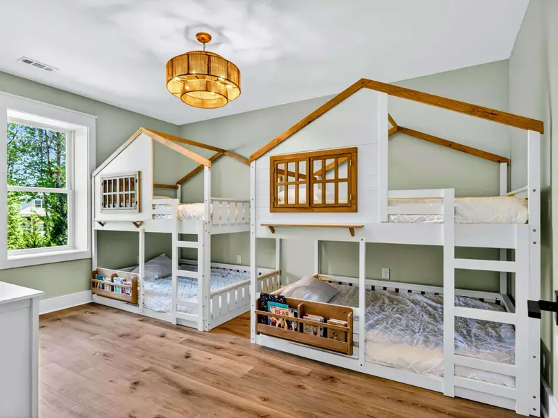 Bunk Room - Four full treehouse bunks, soft green walls, and stocked book nooks make this a dream room for the younger crew.