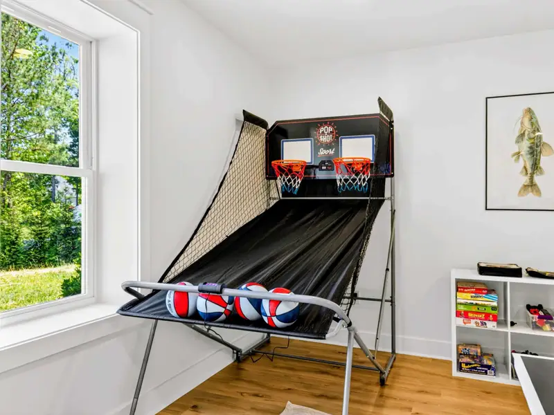 Pop-A-Shot Hoops - Dual-hoop arcade basketball with four balls ready to go, beside a stocked cube of board games for every age.